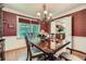 Elegant dining room with hardwood floors, decorative wallpaper, chandelier and natural light at 3592 Midvale Cv, Tucker, GA 30084