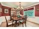 Dining room featuring hardwood floors, chandelier lighting and a view of the lush backyard at 3592 Midvale Cv, Tucker, GA 30084