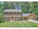 Charming brick two-story home with black shutters and a well-manicured lawn and lush landscaping at 3592 Midvale Cv, Tucker, GA 30084