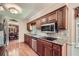 A kitchen showcasing stainless steel appliances, custom cabinets, granite counters, and hardwood floors at 3592 Midvale Cv, Tucker, GA 30084