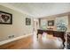 Well-lit office with hardwood floors, classic desk, and view of front yard from large windows at 3592 Midvale Cv, Tucker, GA 30084