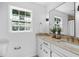 A bathroom showcasing a dual-sink vanity, large mirror, modern fixtures, and a window at 5143 Meadowlake Ln, Dunwoody, GA 30338
