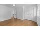 An empty bedroom boasts a double-door closet, light hardwood floors, and white walls at 5143 Meadowlake Ln, Dunwoody, GA 30338