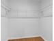 A walk-in closet boasts a neutral color palette, wooden floor, and wire racks for storing clothing at 5143 Meadowlake Ln, Dunwoody, GA 30338