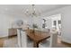 Bright dining room featuring a wooden table with white upholstered chairs and a modern chandelier at 5143 Meadowlake Ln, Dunwoody, GA 30338