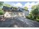 Charming home featuring a three car garage, grey siding, and manicured landscaping at 5143 Meadowlake Ln, Dunwoody, GA 30338