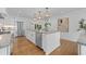 Modern white kitchen with a large island, stainless steel appliances and hardwood floors at 5143 Meadowlake Ln, Dunwoody, GA 30338