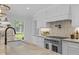 Modern kitchen with stainless steel appliances, a large island, and a view of the backyard at 5143 Meadowlake Ln, Dunwoody, GA 30338