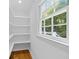 Pantry area featuring ample shelving, a window and views of the outdoors at 5143 Meadowlake Ln, Dunwoody, GA 30338