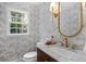 Stylish powder room featuring designer wallpaper, a vanity, and a decorative mirror at 5143 Meadowlake Ln, Dunwoody, GA 30338