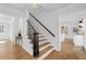 Elegant staircase with hardwood steps and a black railing, illuminated by modern light fixture at 5143 Meadowlake Ln, Dunwoody, GA 30338