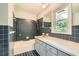 Classic bathroom featuring blue tiles, a bathtub, and a window at 5401 Smoke Rise Dr, Smoke Rise, GA 30087