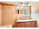 Traditional bathroom featuring a window, tiled walls, and a vanity sink at 5401 Smoke Rise Dr, Smoke Rise, GA 30087