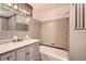 Cozy bathroom featuring gray tiling, bathtub, and marble top vanity at 5401 Smoke Rise Dr, Smoke Rise, GA 30087