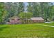 Charming brick and siding home with a well-manicured lawn and mature trees at 5401 Smoke Rise Dr, Smoke Rise, GA 30087