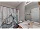 This is a bathroom with neutral colored walls, a marble shower curtain, a white sink, and a mirror at 1171 Pine Acre Dr, Sugar Hill, GA 30518