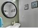 Charming powder room with a round mirror and stylish decor at 1171 Pine Acre Dr, Sugar Hill, GA 30518