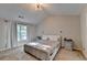 Bright bedroom with carpeted floors featuring large window, vaulted ceiling, and modern ceiling fan at 1171 Pine Acre Dr, Sugar Hill, GA 30518