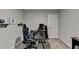 This is a bedroom with neutral walls and carpeting, a desk, and a gaming chair at 1171 Pine Acre Dr, Sugar Hill, GA 30518