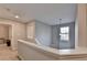 Hallway with neutral walls featuring pendant light with white railing and carpeted floor at 1171 Pine Acre Dr, Sugar Hill, GA 30518