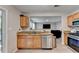 Modern kitchen with stainless steel appliances, granite countertops, and a view of the living room at 1171 Pine Acre Dr, Sugar Hill, GA 30518