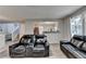 Inviting living room featuring a comfortable black leather sofa and a view into the kitchen at 1171 Pine Acre Dr, Sugar Hill, GA 30518
