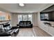 Spacious living room with hardwood floors, large windows, and a sleek black leather sofa at 1171 Pine Acre Dr, Sugar Hill, GA 30518