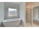 Bathroom featuring soaking tub, marble floors, and glass-enclosed shower at 600 Sidney Ct, Stockbridge, GA 30281