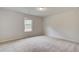 A carpeted bedroom with a window and neutral walls offers a serene and adaptable space at 600 Sidney Ct, Stockbridge, GA 30281
