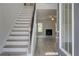 Inviting foyer with light wood-look floors, a staircase, and a view into the living room with a fireplace at 600 Sidney Ct, Stockbridge, GA 30281