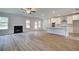 Open-concept living room with hardwood flooring, fireplace, and a view of the modern kitchen at 600 Sidney Ct, Stockbridge, GA 30281