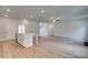 Open-concept living room and kitchen with wood floors, white island, and stairs at 600 Sidney Ct, Stockbridge, GA 30281