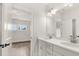 Bright bathroom with double sink vanity, quartz countertop and view into an adjacent room with hardwood floors at 1005 Coleman Place Dr, Roswell, GA 30075