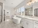 Bright bathroom featuring a large bathtub, double vanities, and a separate glass-enclosed shower at 1005 Coleman Place Dr, Roswell, GA 30075