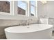 Close-up of a soaking tub with elegant fixtures, complemented by large windows at 1005 Coleman Place Dr, Roswell, GA 30075