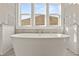 Close-up of a soaking tub with elegant fixtures, complemented by large windows at 1005 Coleman Place Dr, Roswell, GA 30075