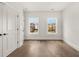 Bright bedroom featuring hardwood floors, two windows, and a connecting door at 1005 Coleman Place Dr, Roswell, GA 30075