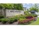 Stone community entrance sign amidst colorful landscaping and manicured greenery at 1005 Coleman Place Dr, Roswell, GA 30075