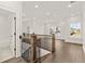 Upstairs hallway with hardwood floors, metal railing, and natural light at 1005 Coleman Place Dr, Roswell, GA 30075