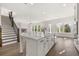 White kitchen with island, stainless steel appliances, and open concept to living room and stairway at 1005 Coleman Place Dr, Roswell, GA 30075