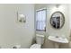 Half bathroom features a pedestal sink, oval mirror, and soft lighting at 2365 Valley Mill Dr, Buford, GA 30519