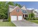 View of the home's brick and siding exterior, showcasing the two-car garage and landscaping at 2365 Valley Mill Dr, Buford, GA 30519