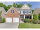 Charming two-story home featuring a brick facade, a two-car garage, and a well-manicured lawn at 2365 Valley Mill Dr, Buford, GA 30519
