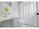 Bathroom featuring sink with gray cabinet, tile floor, toilet, and shower with patterned curtain at 4004 Charrwood Trce, Marietta, GA 30062
