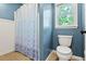 Bathroom featuring a shower/tub combination, toilet, and window providing natural light at 4004 Charrwood Trce, Marietta, GA 30062