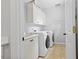 Bright laundry room featuring a sink, white cabinets, and modern appliances at 4004 Charrwood Trce, Marietta, GA 30062