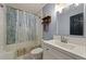 Bathroom with a shower over bath with shower curtain and a sink and vanity at 6645 N Glen Dr, Cumming, GA 30028