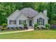 Charming single-Gathering home featuring a well-manicured lawn, complemented by decorative shrubs and classic architectural details at 6645 N Glen Dr, Cumming, GA 30028