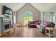 Bright living room boasting vaulted ceilings, a cozy fireplace, large windows offering scenic views, and hardwood floors at 6645 N Glen Dr, Cumming, GA 30028