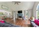 Open concept living space with vaulted ceilings, featuring a stone fireplace, large windows, and hardwood flooring at 6645 N Glen Dr, Cumming, GA 30028